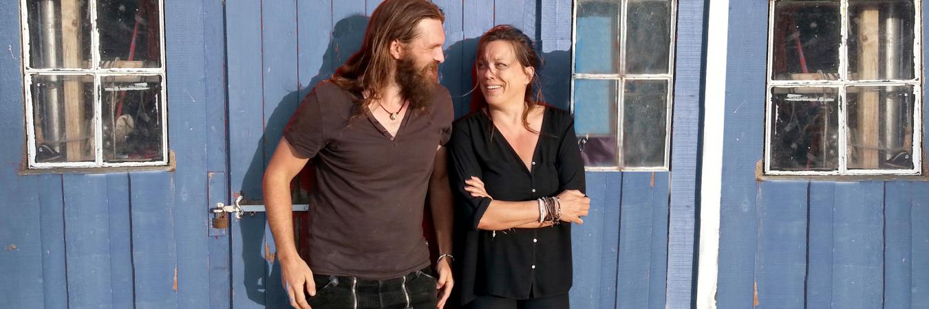 Carsten und Kathi vor Bretterbude schauen sich fröhlich an